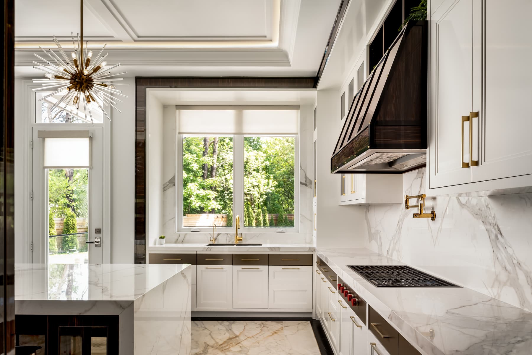 Kitchen with sputnik-cluster chandelier and ebony macassar hood.