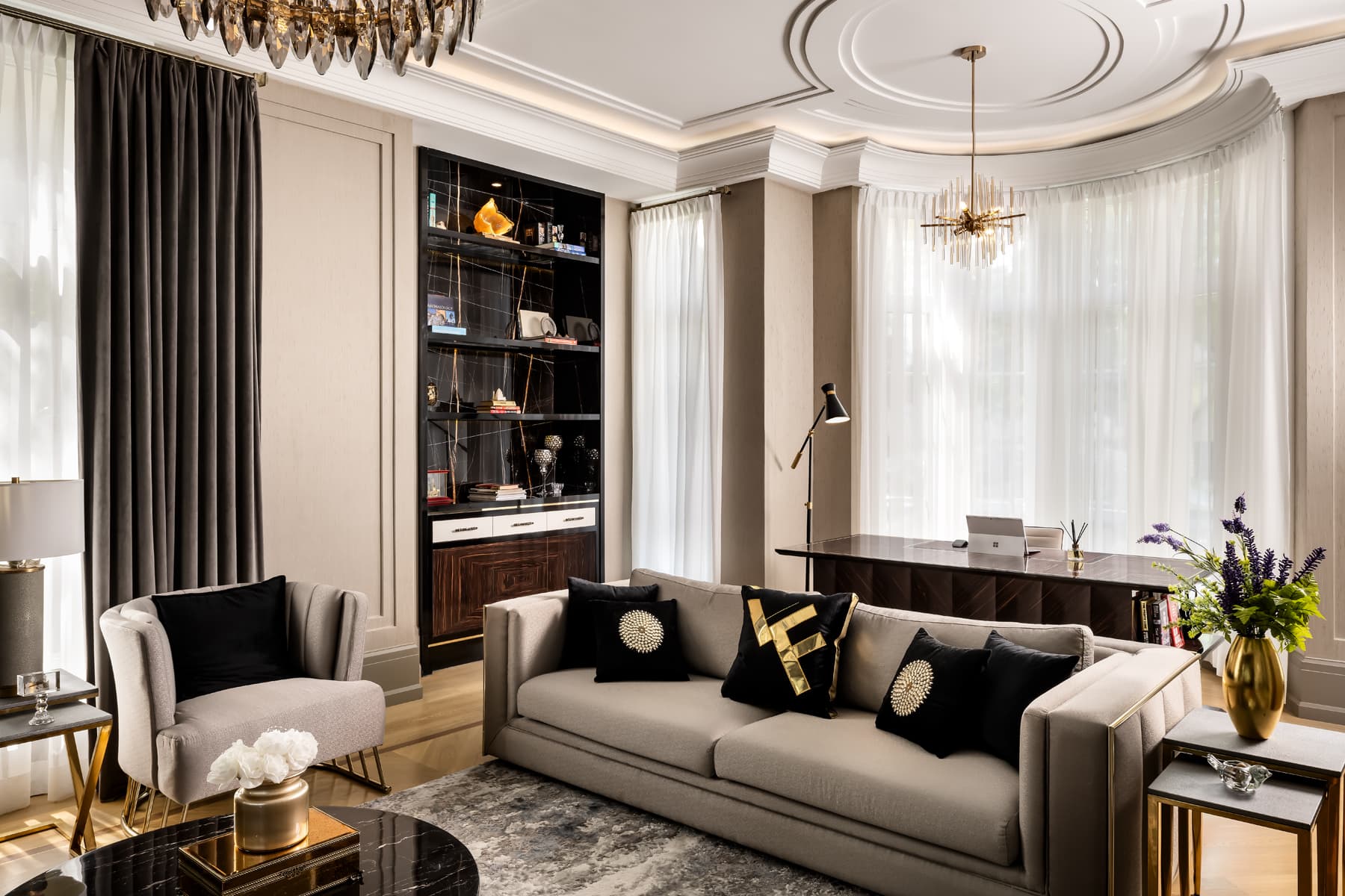 Study with ebony bookcase, layered drapery, and a sputnik chandelier over a sitting group.